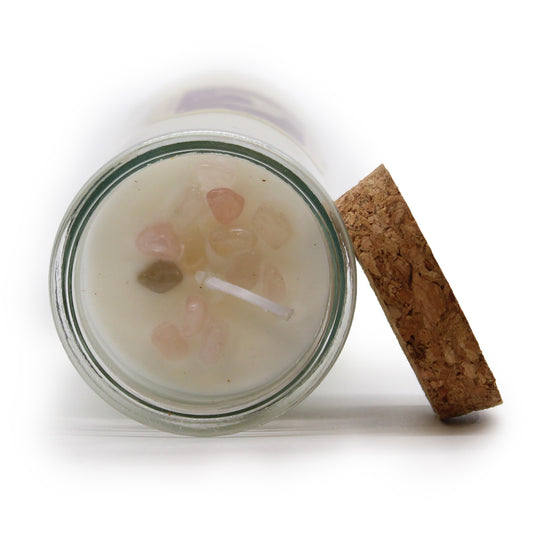 Candle in a glass jar with a cork lid on a white background