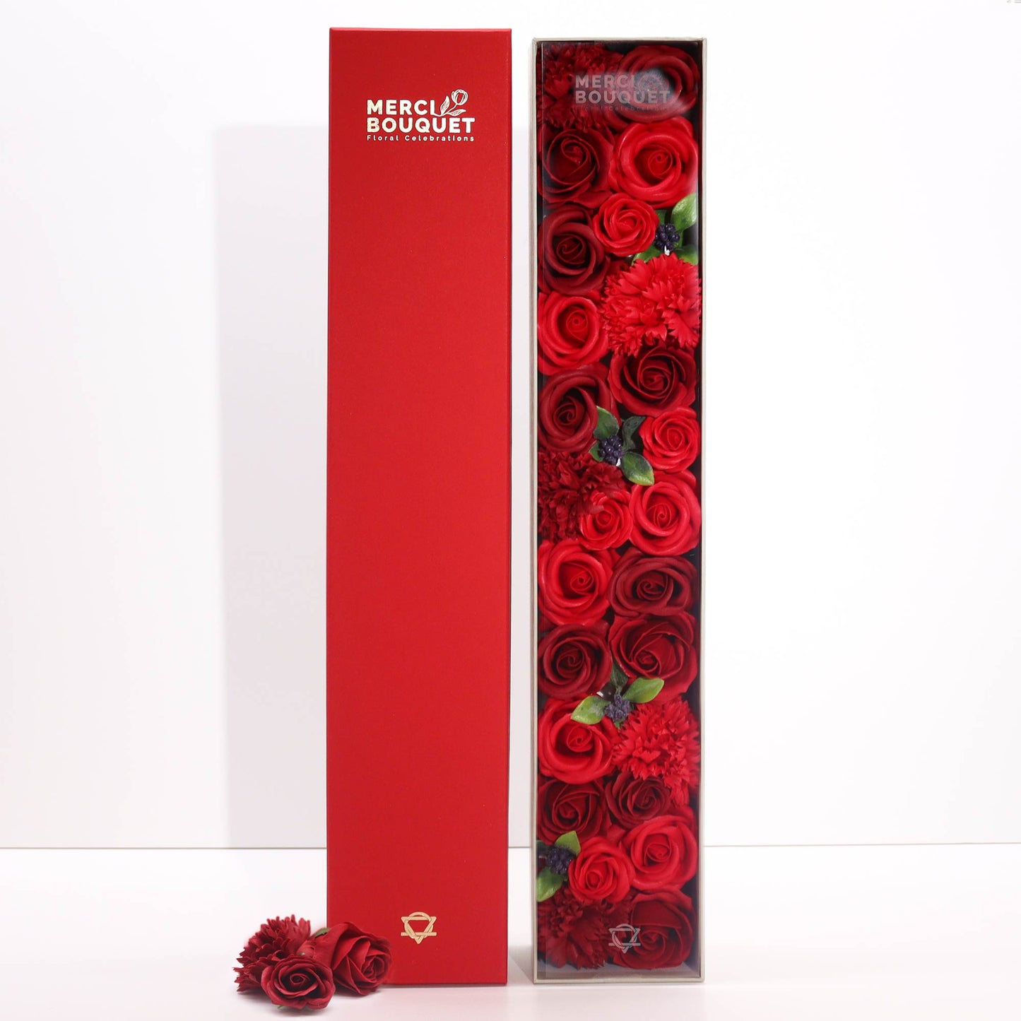 Long rectangular box filled with red roses with a red cover displaying 'Merci Bouquet' logo.