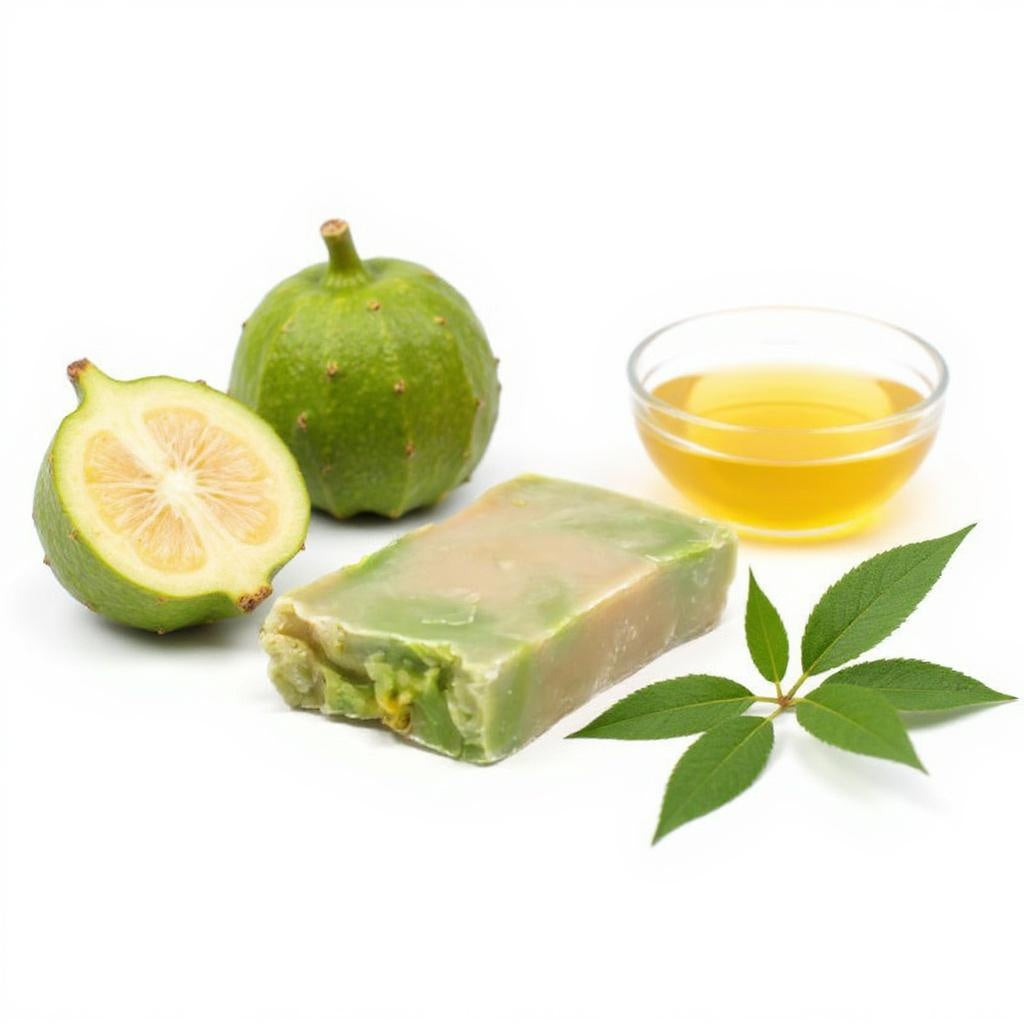 Green soap bar with a halved green fruit, a glass of yellow liquid, and leaves on a white background