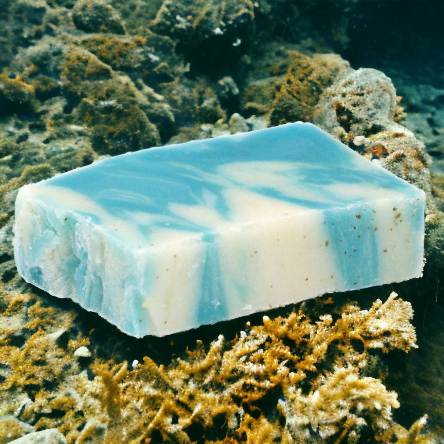 A bar of seaweed olive oil soap resting on a surface with a blue and white marbled pattern.