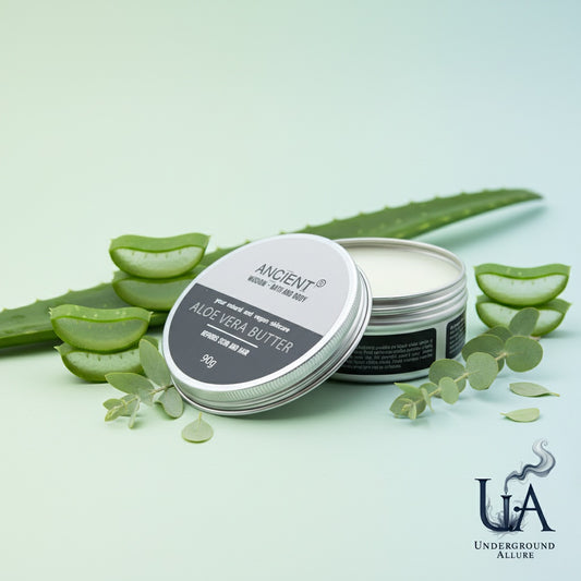 Aloe Vera Butter by Ancient Wisdom, open tin presented with fresh aloe vera leaves and greenery, on a clean, calming background featuring the Underground Allure logo.