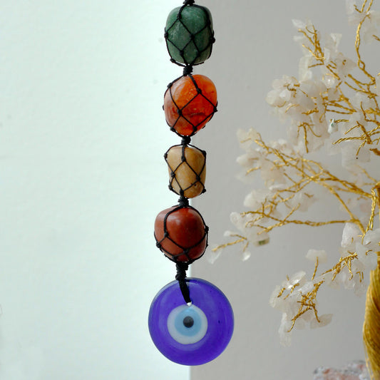 Hanging Chakra Stone Pendant - Evil Eye with a blue evil eye pendant against a light background