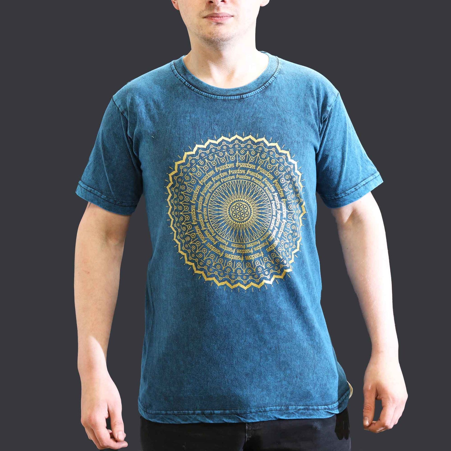 Person wearing a blue t-shirt with a gold mandala design on a dark background