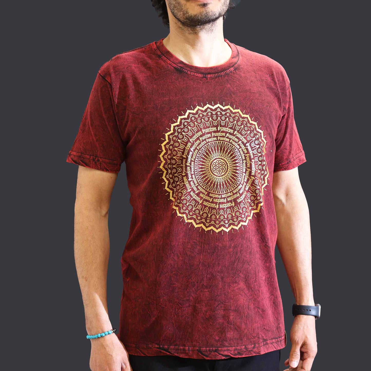 Maroon t-shirt with a gold mandala design worn by a person on a dark background