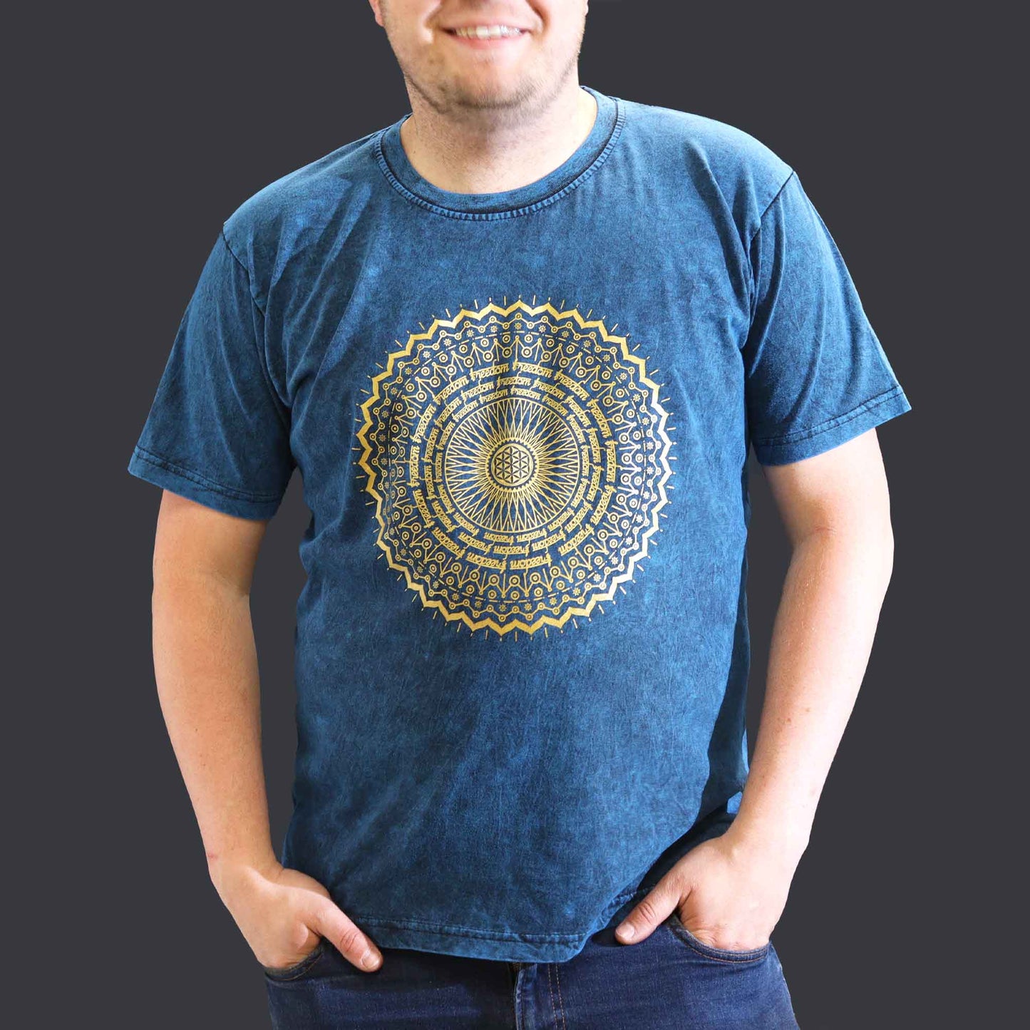 Person wearing a blue t-shirt with a gold mandala design on a dark background