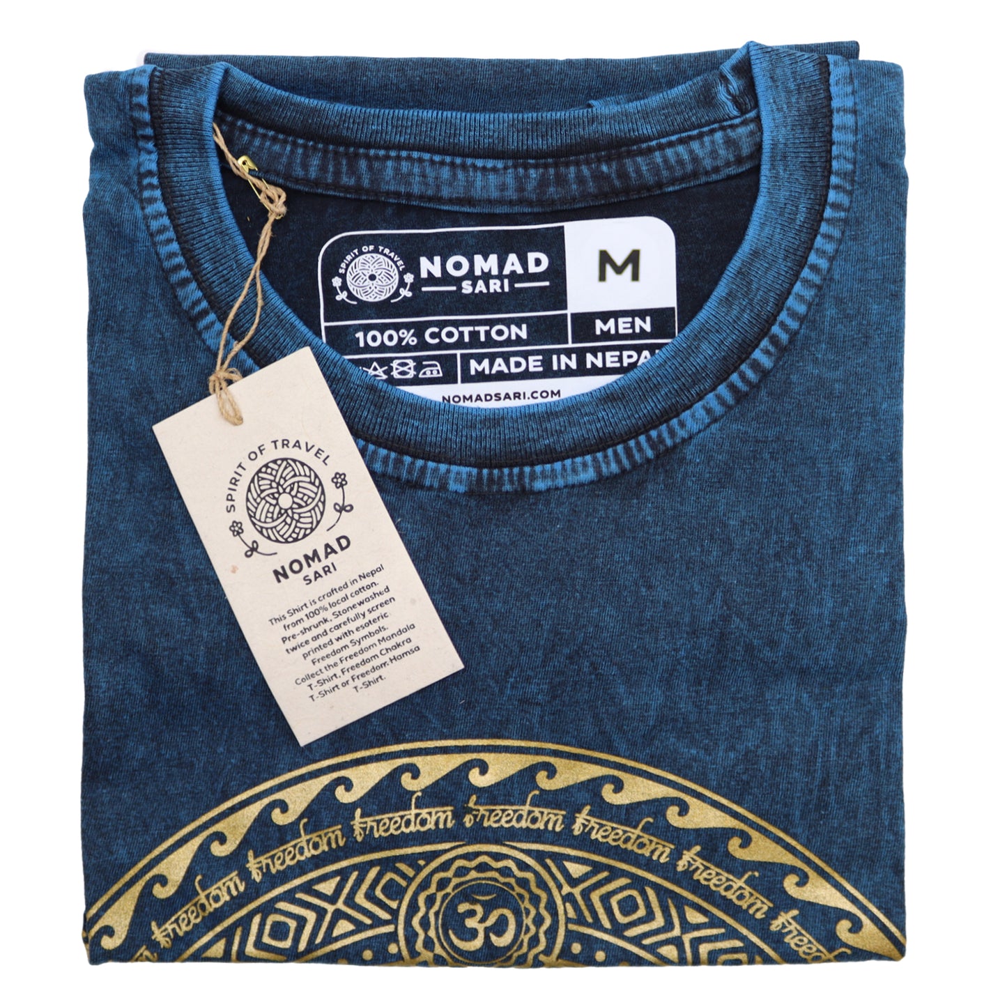 Folded blue t-shirt with gold design and Nomad Sari tag on a white background