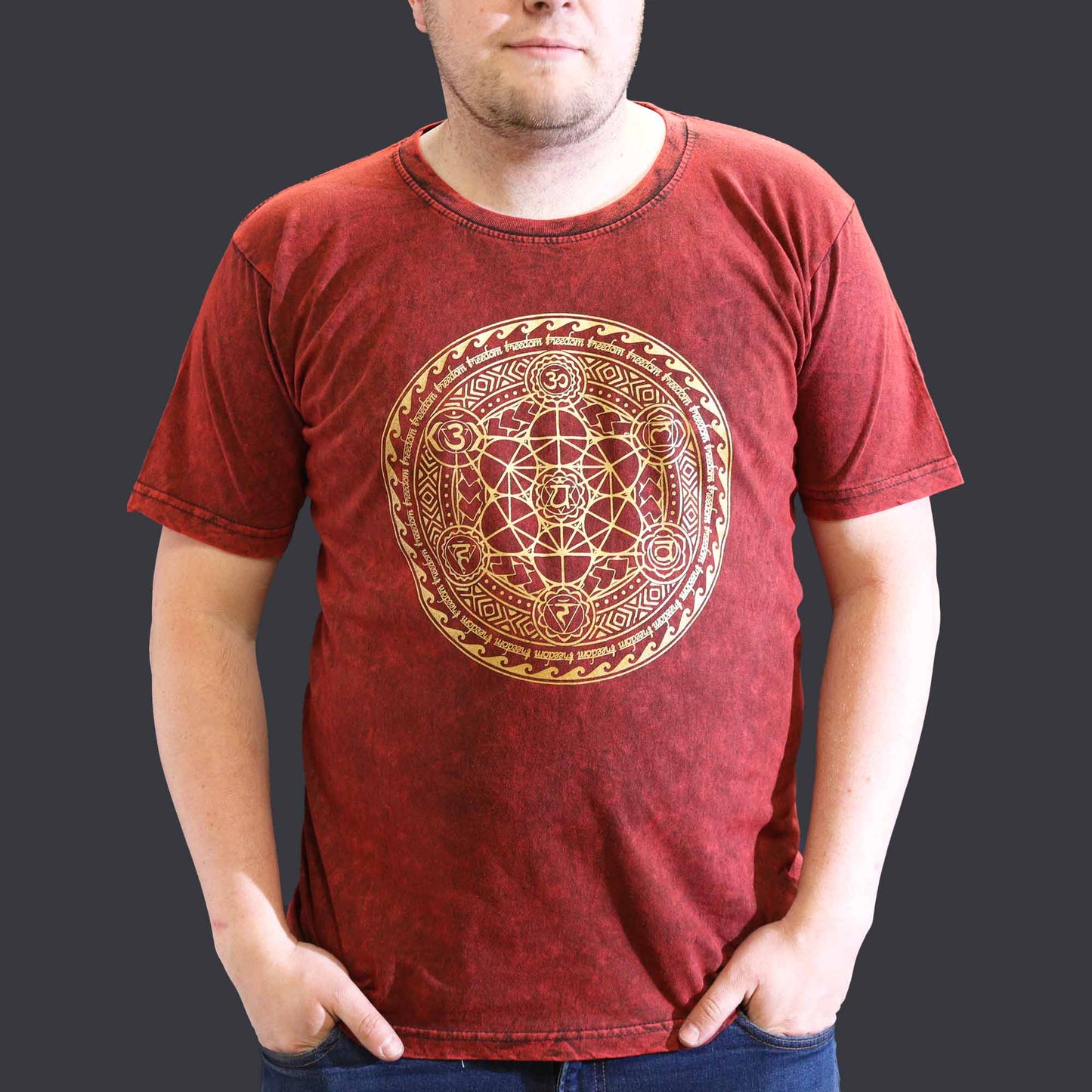 Person wearing a red t-shirt with a gold geometric design on a dark background