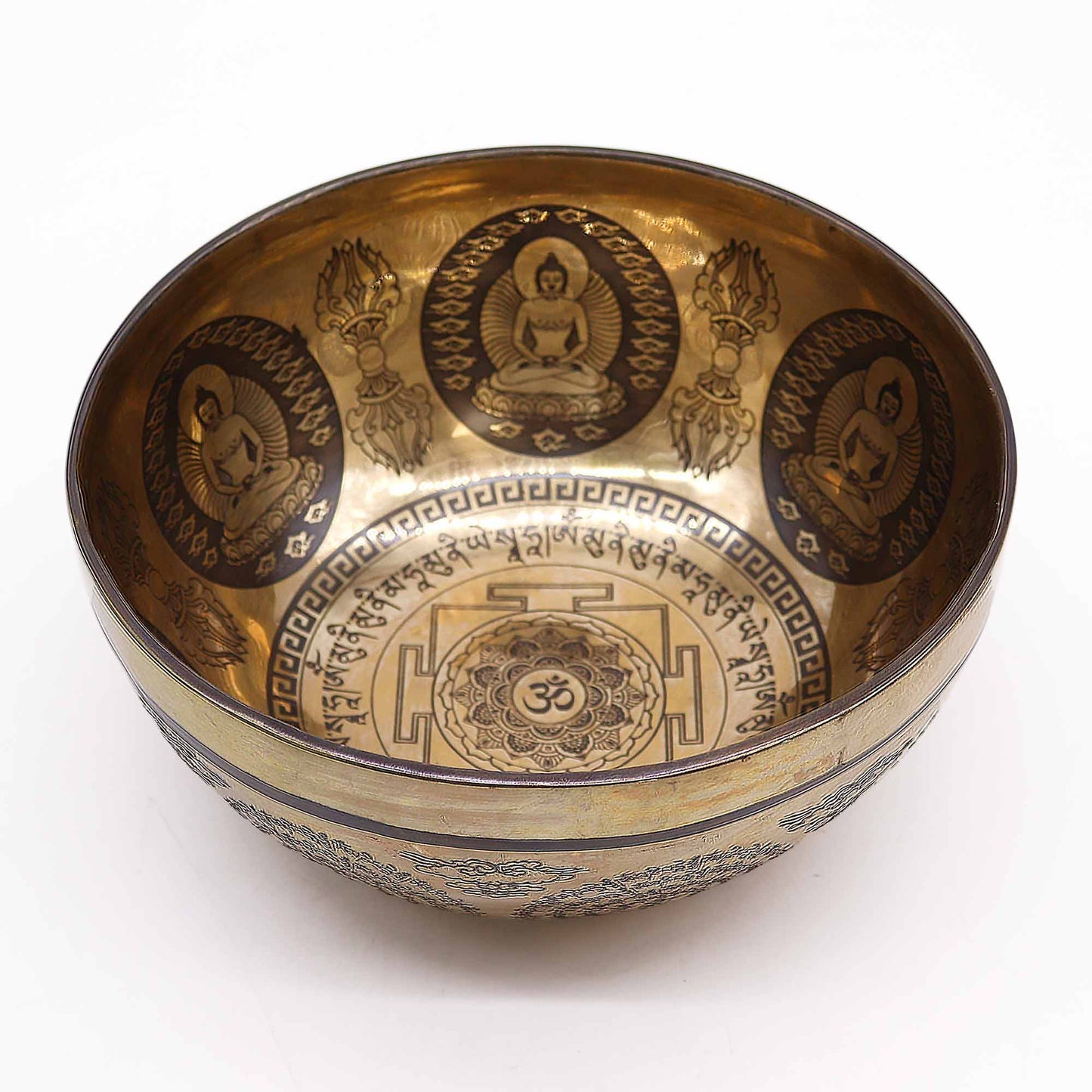 An engraved Tibetan singing bowl with intricate designs and symbols representing the 7 chakras, predominantly in a bronze or brown color.Underground Allure, Essex UK