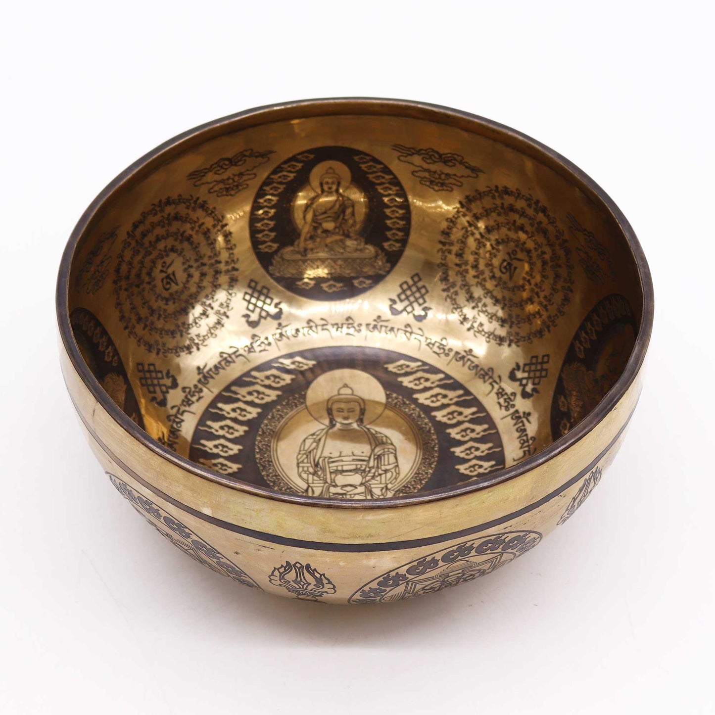 An engraved Tibetan singing bowl with intricate designs and symbols representing the 7 chakras, predominantly in a bronze or brown color. v