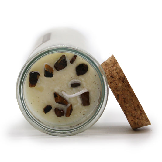 Jar of dessert with chocolate chunks and a cinnamon stick on a white background