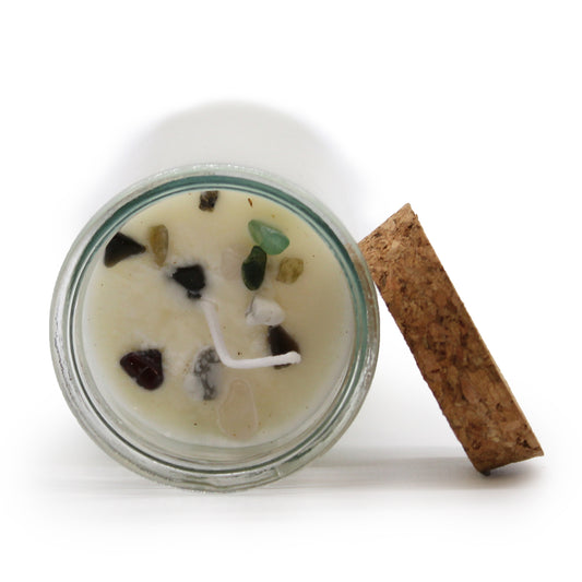 Candle in a glass jar with decorative elements and a cork lid on a white background