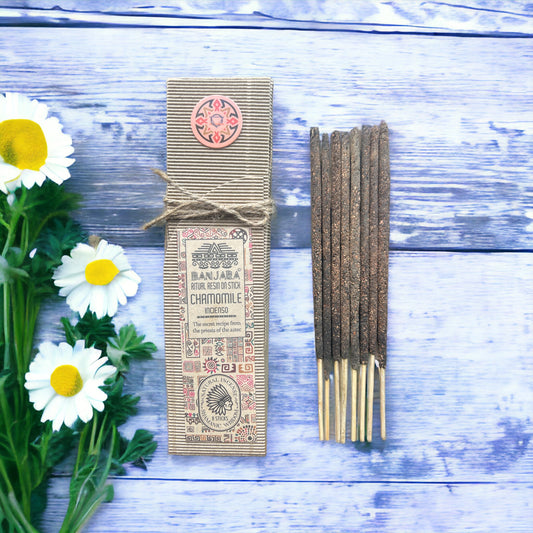 Incense sticks with packaging on a wooden surface with flowers