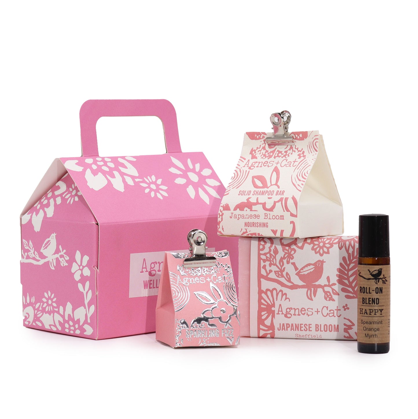 Set of Agnes & Cat Japanese Bloom products including a pink box, small bottles, and a rollerball on a white background.