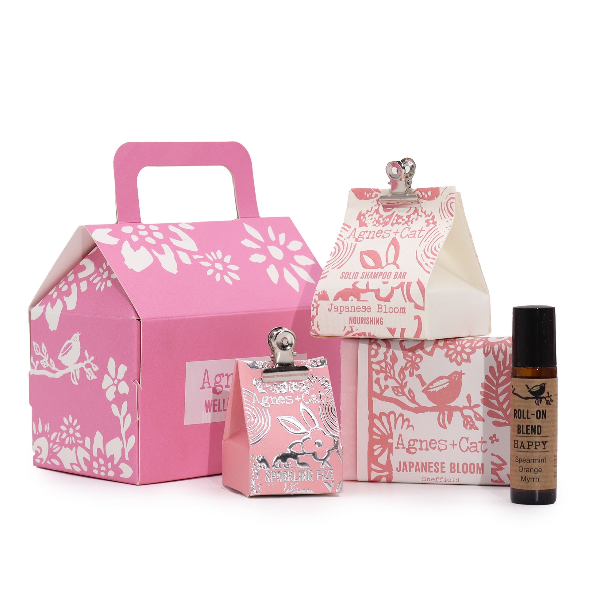 Set of Agnes & Cat Japanese Bloom products including a pink box, small bottles, and a rollerball on a white background.