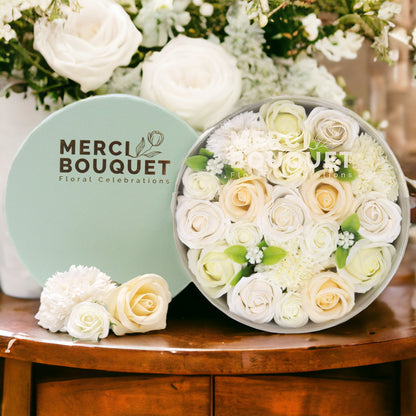 Floral arrangement in a box with 'Merci Bouquet' branding on a wooden table.