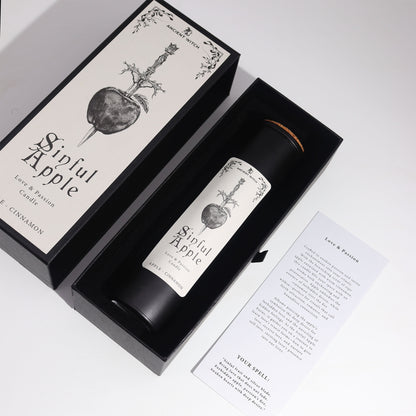 Overhead view Candle labeled 'Sinful Apple' in a black box with decorative design on a white background