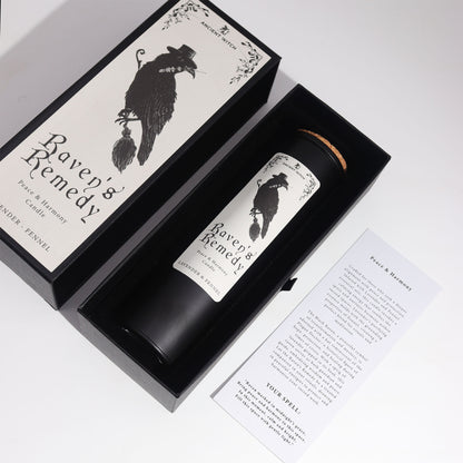 Candle labeled 'Raven's Remedy' in a decorative box and information card on a white background