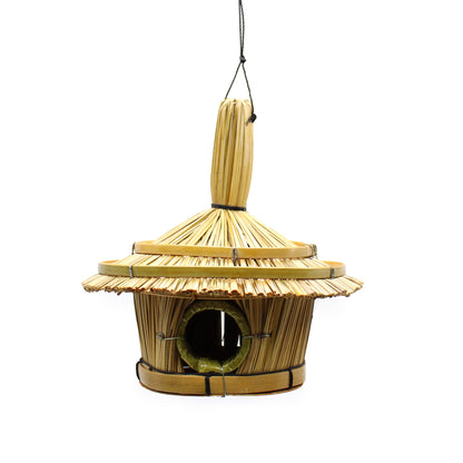 Wooden birdhouse with a thatched roof on a white background