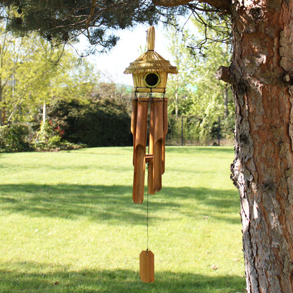 Wooden Birdhouse & wind chime hanging from a tree in a garden setting
