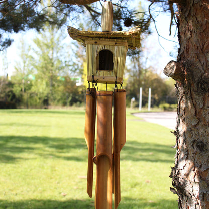 Bamboo wind chime attached to a tree with a park-like background
