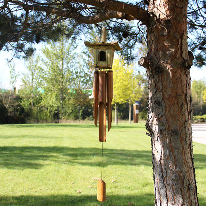 Wooden wind chime hanging from a tree in a park setting