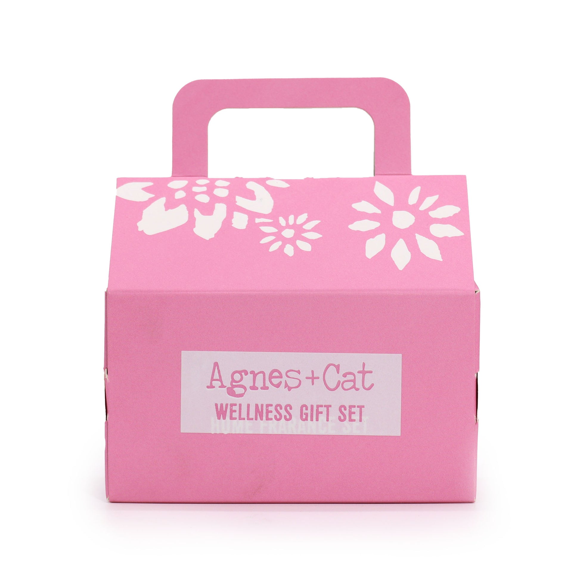 Pink gift box with white floral designs and 'Agnes + Cat Wellness Gift Set' label on a white background
