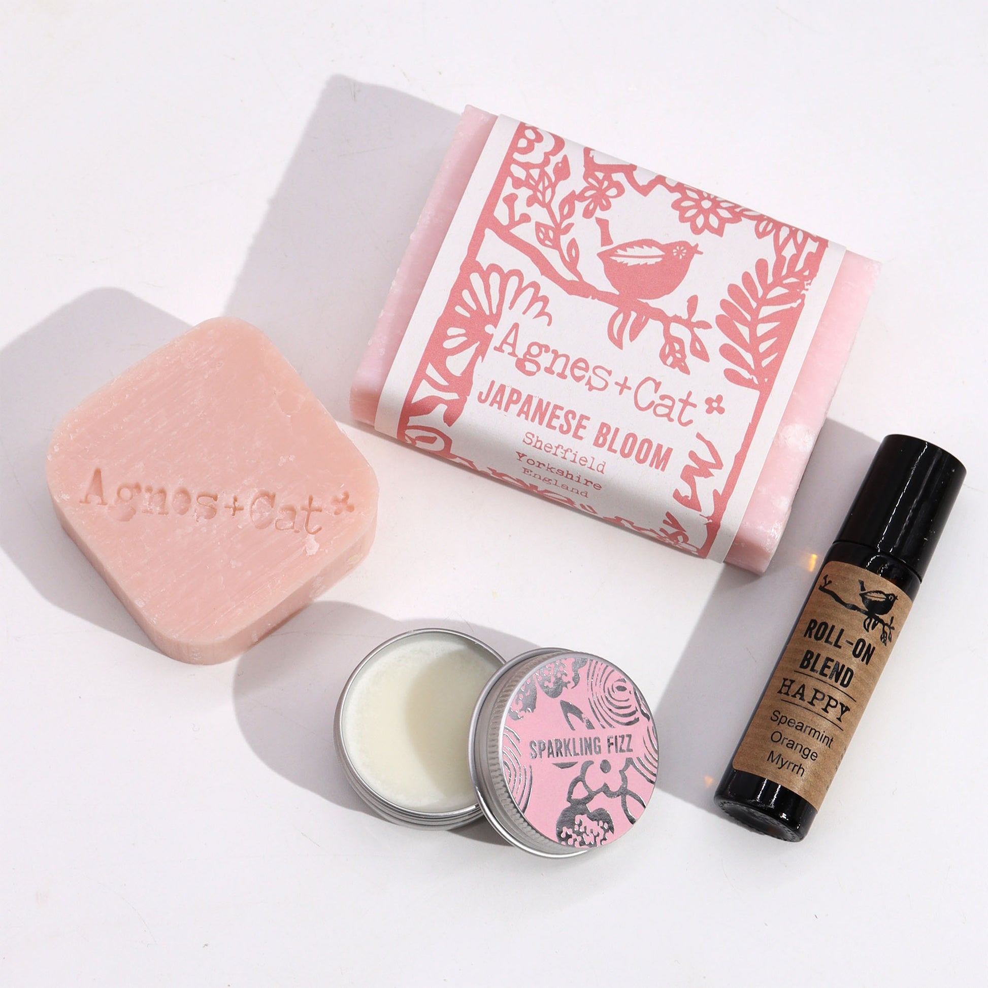 Collection of Agnes + Cat products including soap, candle, and roll-on blend on a white background