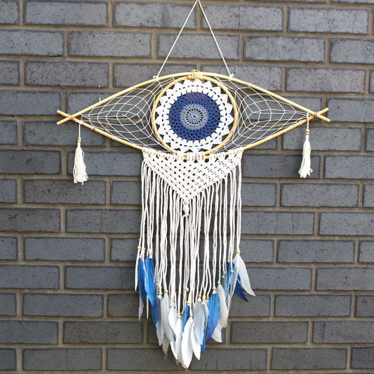 Decorative dreamcatcher with feathers hanging on a brick wall