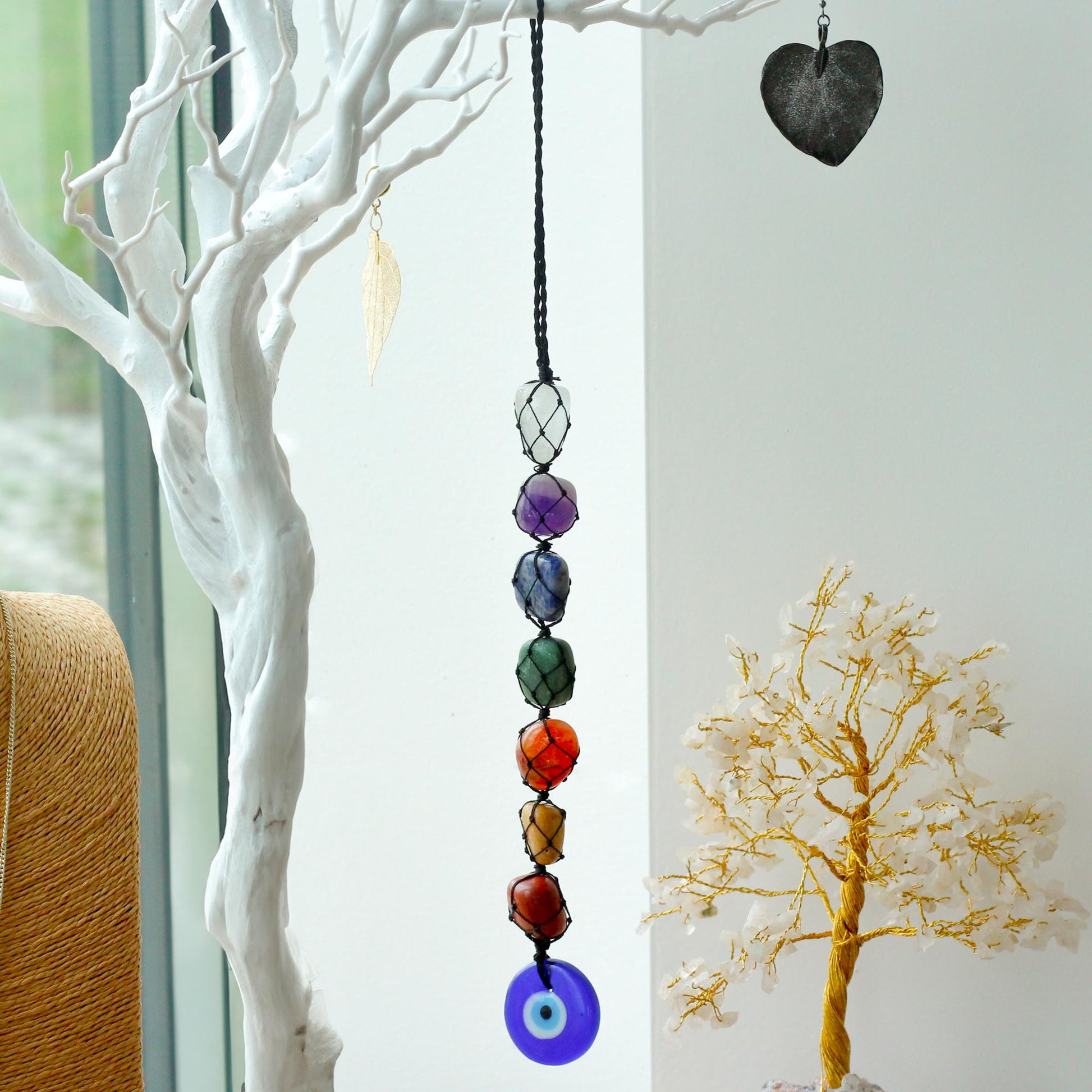 Hanging Chakra Stone Pendant - Evil Eye hanging from a tree branch  