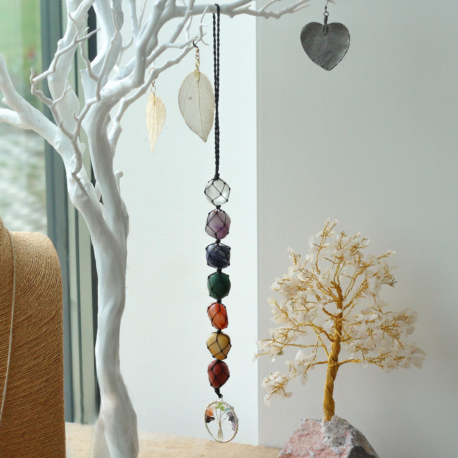 Hanging Chakra Stone Pendant - Tree of Life on a white branch against a neutral background