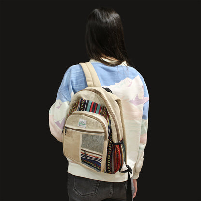 Person wearing a beige backpack with colorful patterns on a black background
