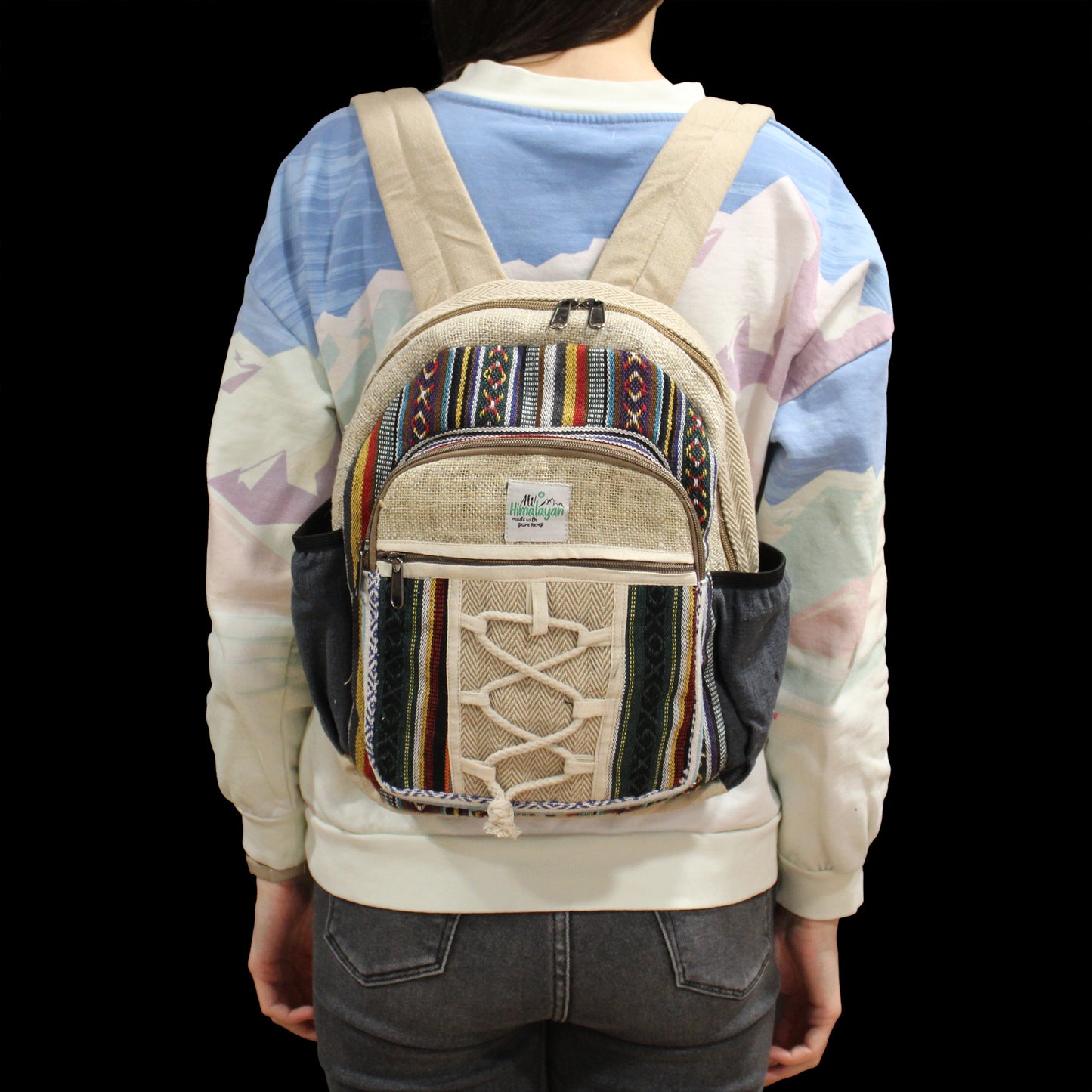 Person wearing a colorful backpack with a patterned design on a black background