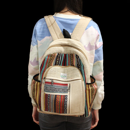 Person wearing a beige backpack with colorful patterns on a black background