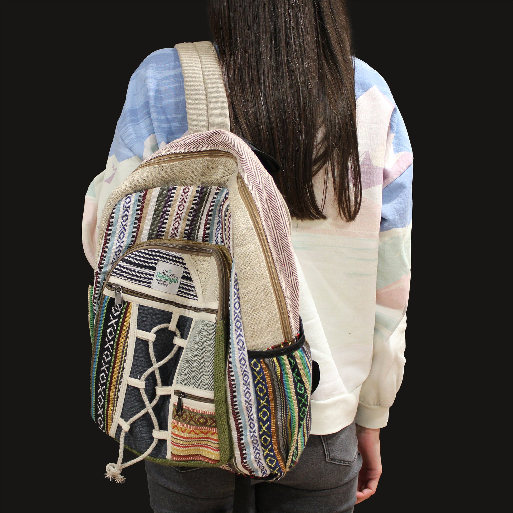 Person wearing a colorful patterned backpack on a plain background