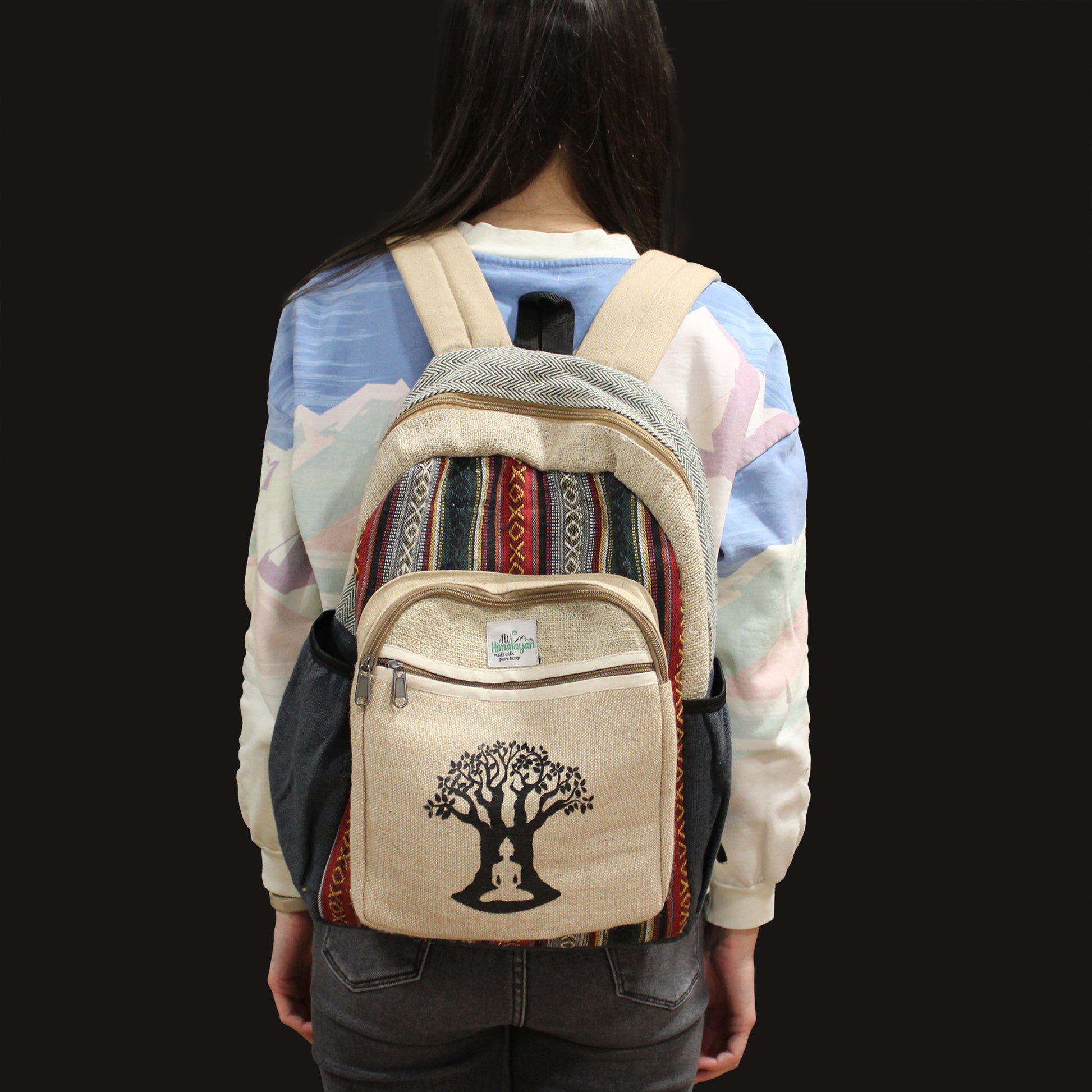 Person wearing a backpack with a tree design on a plain background