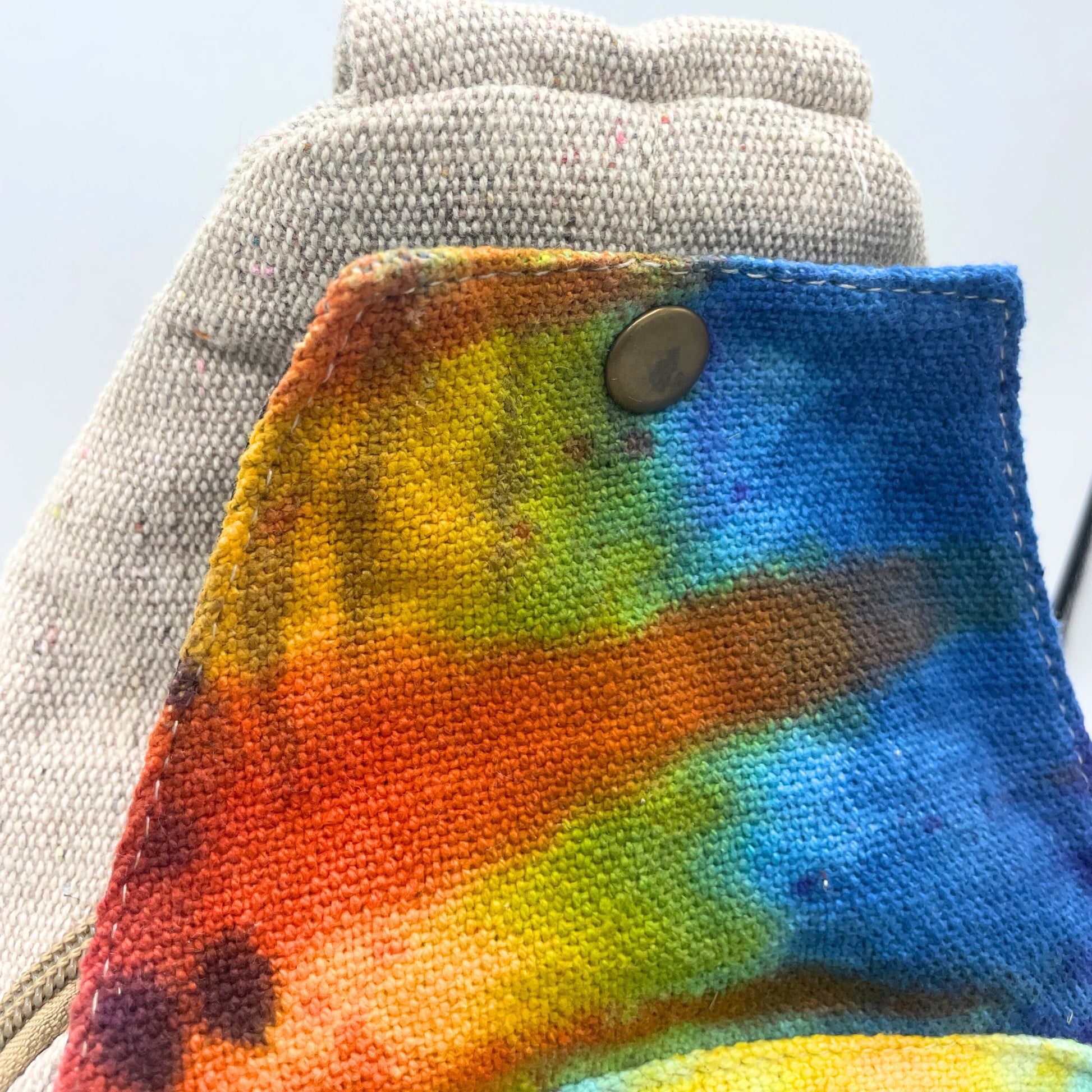 Colorful tie-dye towel with a button on a gray towel background