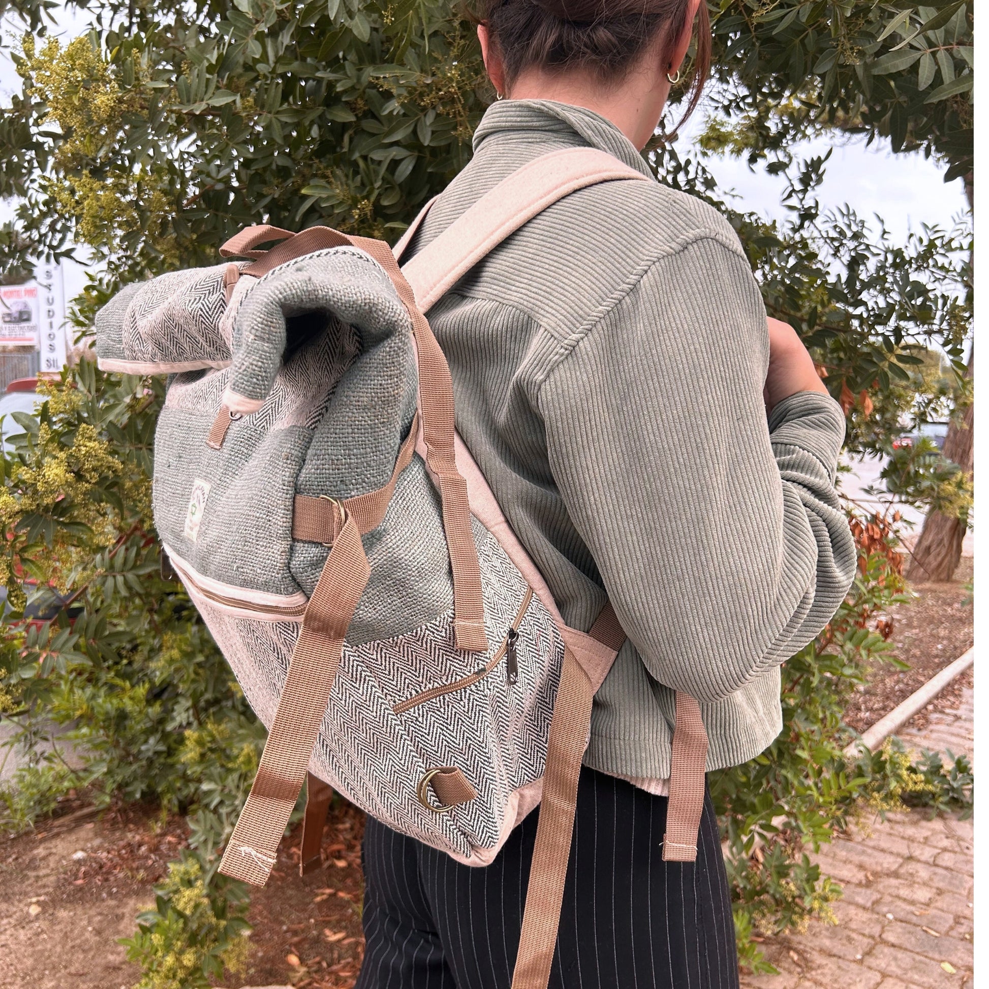 Person wearing a textured backpack with beige straps outdoors