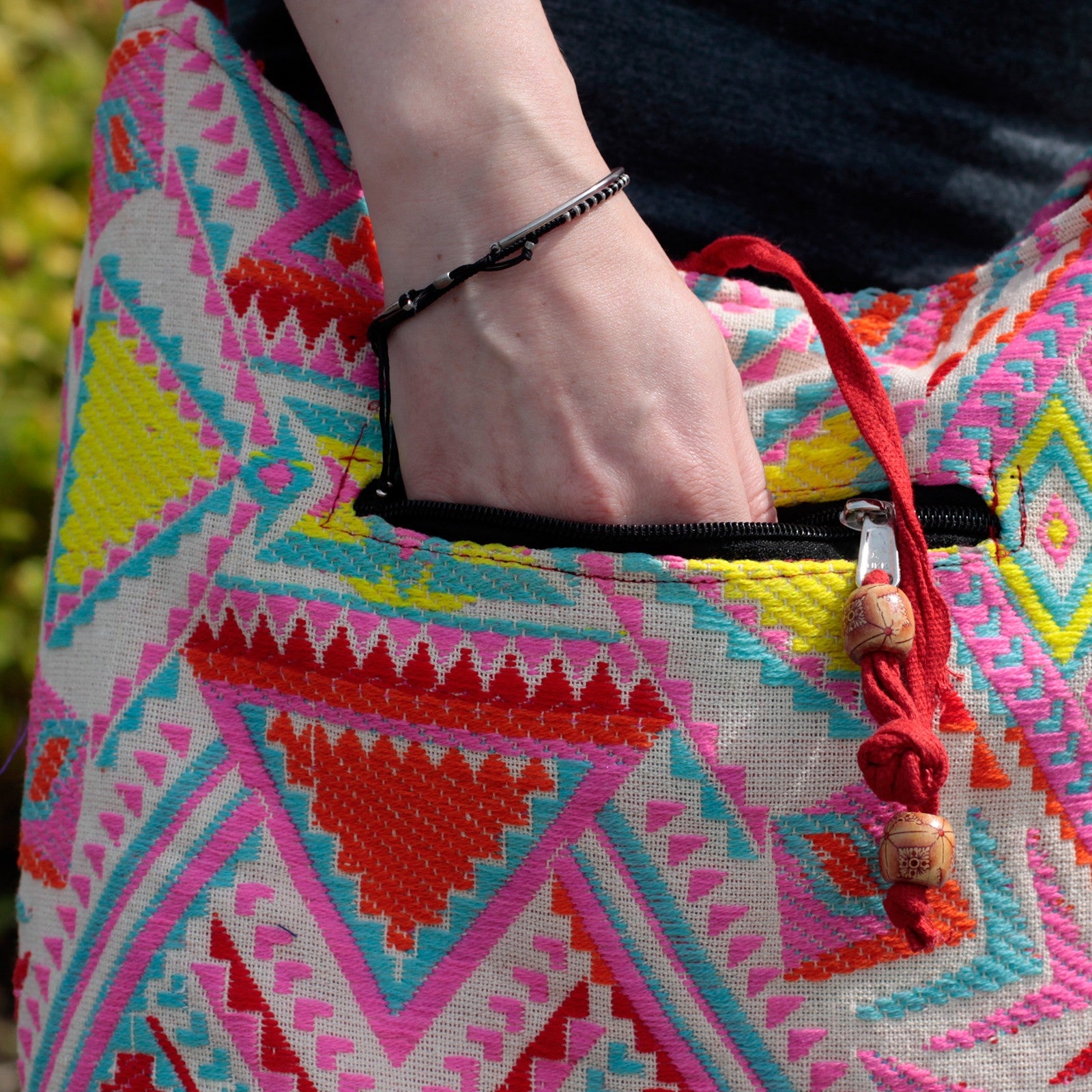 close up shot of a woman hand in the pouch of her Kathmandu Big Bag - Midday