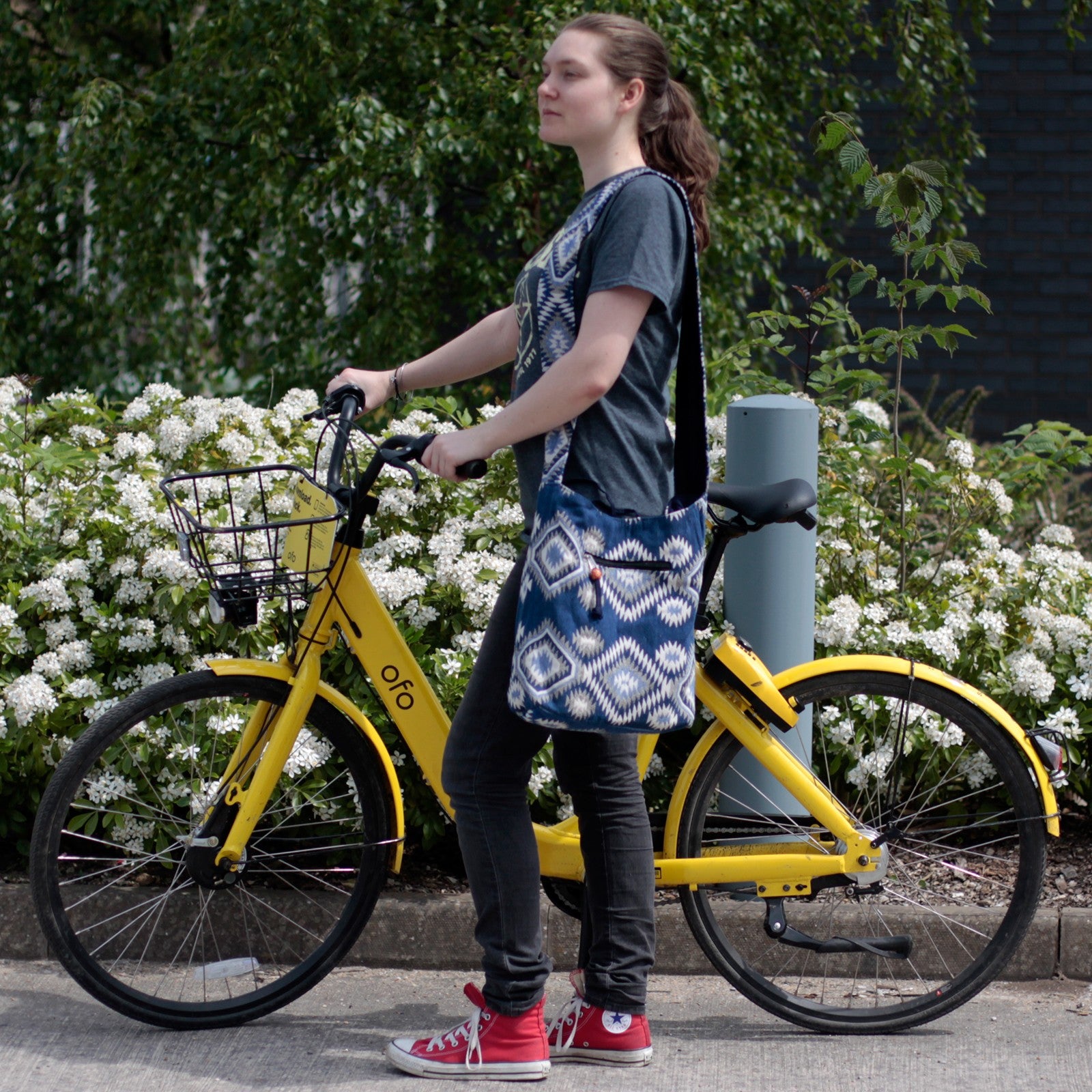 women with her yellow bike and she wearing her blue Kathmandu Big Bag - Midday