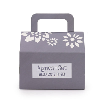 Gray gift box with floral designs and 'Agnes + Cat Wellness Gift Set' label on a white background