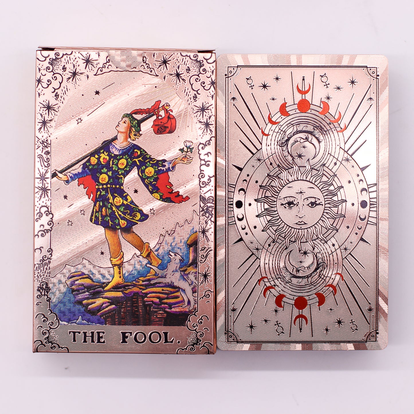 Two tarot cards, 'The Fool' on the left and a decorative card with celestial design on the right, against a white background.