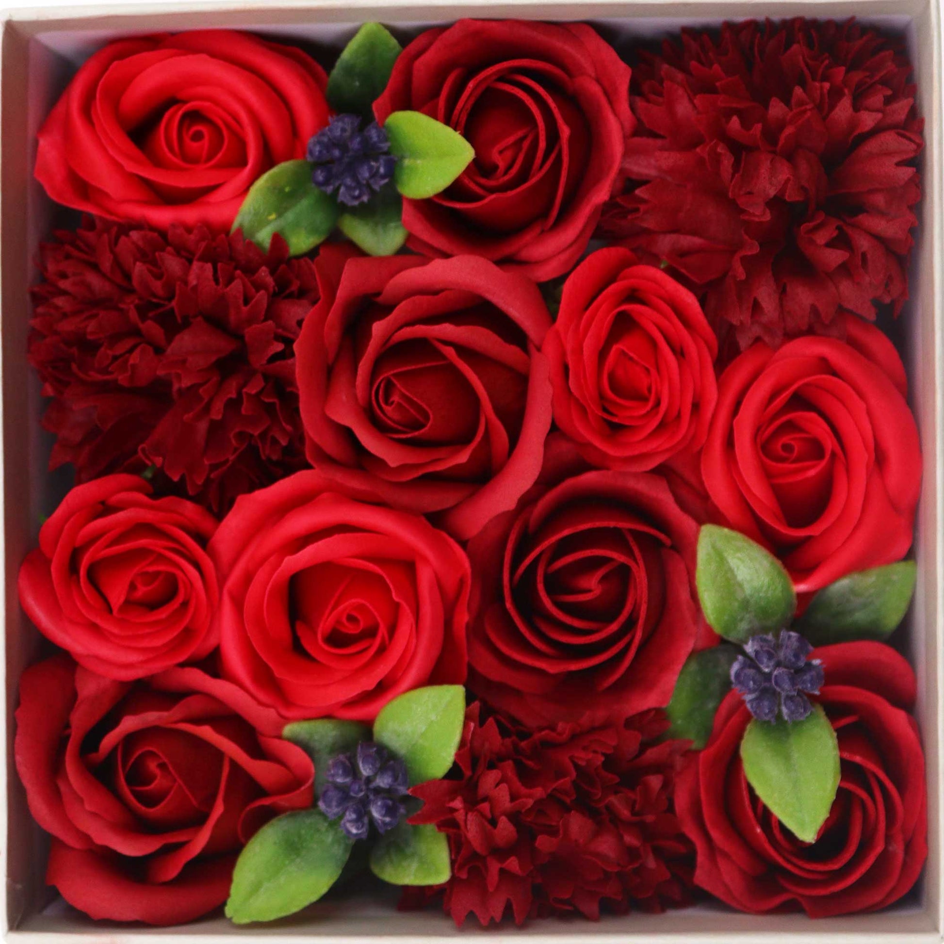 Box of red roses and red carnations with green leaves and purple flowers.