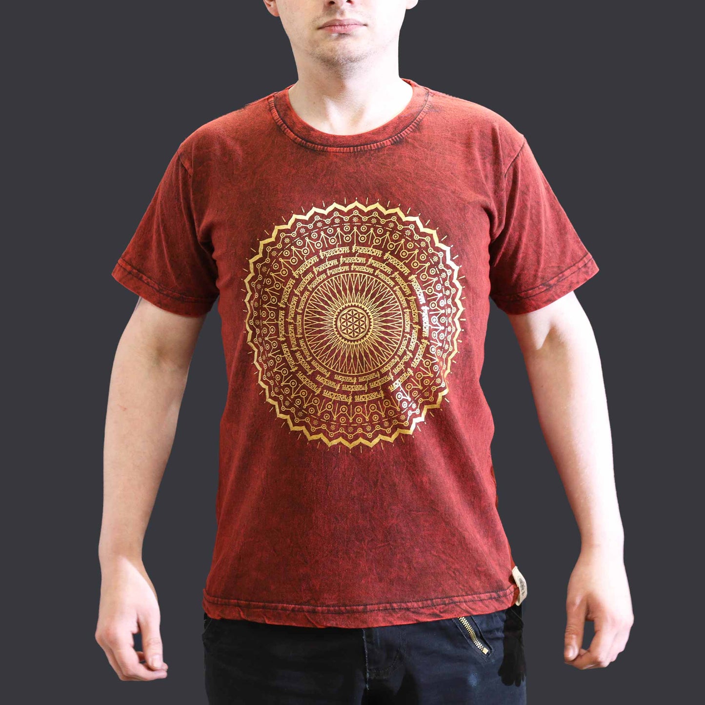 Red t-shirt with a gold mandala design worn by a person on a dark background
