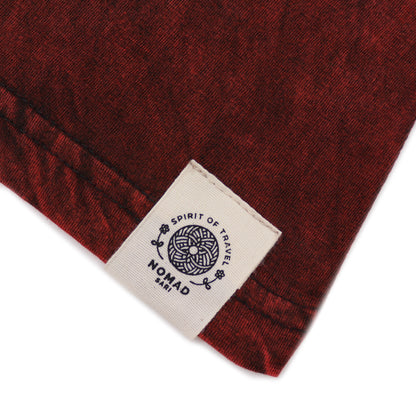 Close-up of a red fabric with a visible brand label on a white background