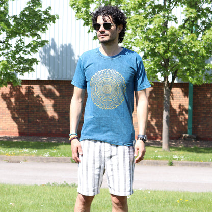 Man wearing black sun glasses a blue t-shirt with a yellow design outdoors