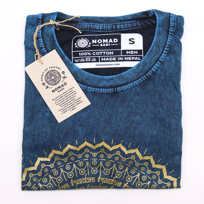 Folded blue t-shirt with gold design and 'Nomad Sari' label on a white background
