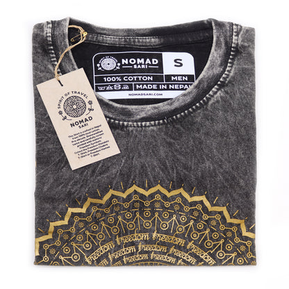 Folded black t-shirt with gold embroidery and 'Nomad Sari' tag on a white background