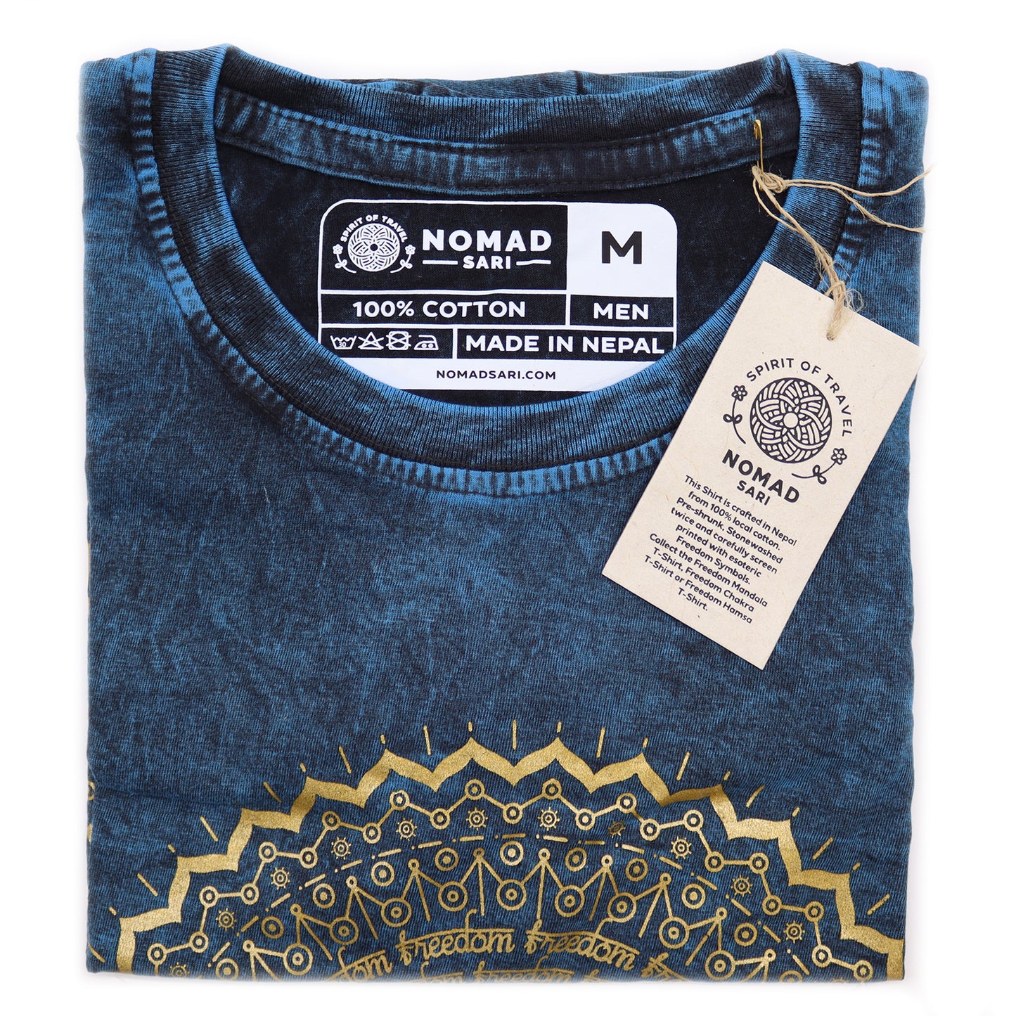 Folded blue t-shirt with gold patterns and 'Nomad Sari' label on a white background
