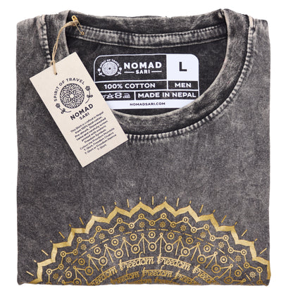 Folded black t-shirt with gold embroidery and 'Nomad Sari' label on a white background