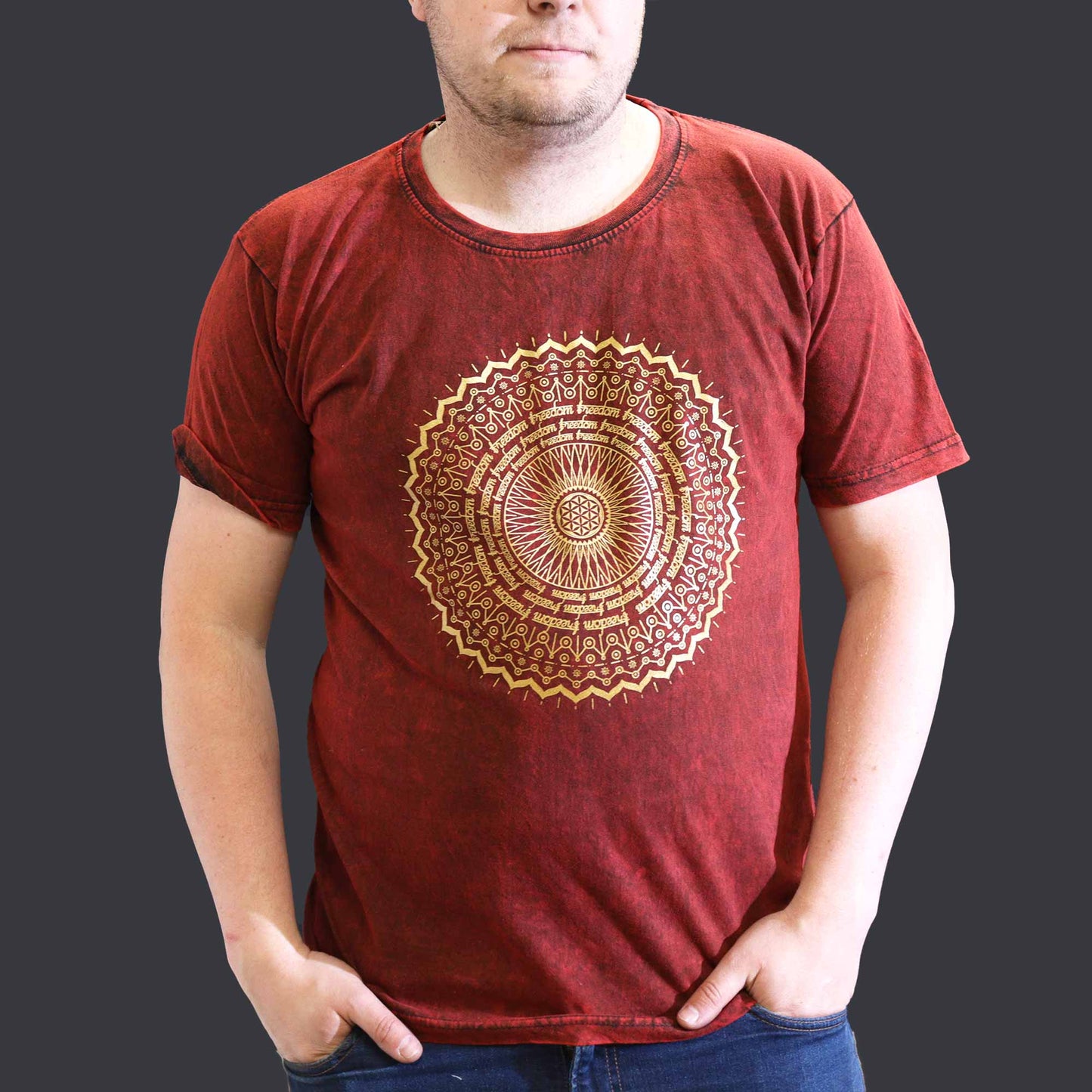 Man wearing a red t-shirt with a gold mandala design on a plain background